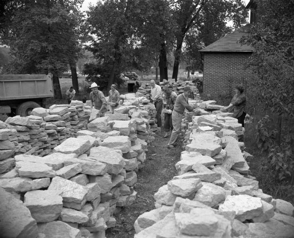 Members of the Madison First Unitarian Society congregation sorting stones to be used in the construction of the Meeting House. The building was designed by Frank Lloyd Wright, and the congregation assisted in the construction in order to save money.