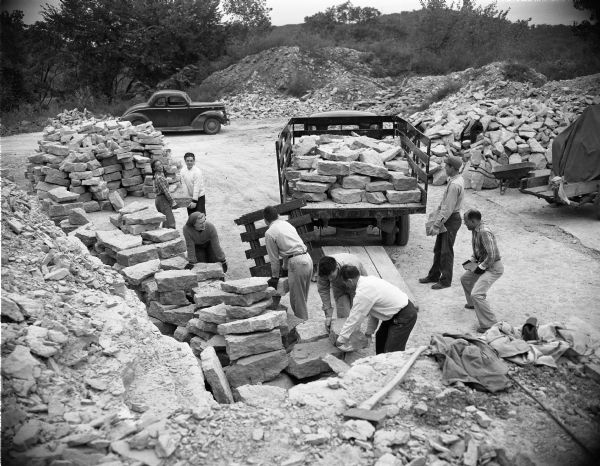 Members of the First Unitarian Society loading stones at a quarry to be used in the construction of the Meeting House. The building was designed by Frank Lloyd Wright. The members of the congregation assisted in the construction in order to save money.