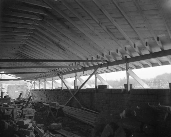 Interior view of the classroom space in the First Unitarian Society Meeting House during construction. Window openings and the roof construction are shown. The building was designed by Frank Lloyd Wright.