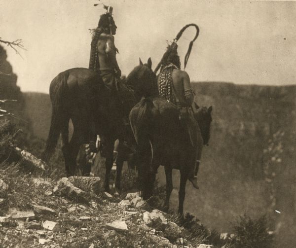 Two plains Indians on horseback.