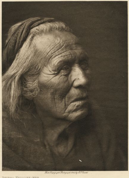 Head and shoulders portrait of a Navaho medicine man.