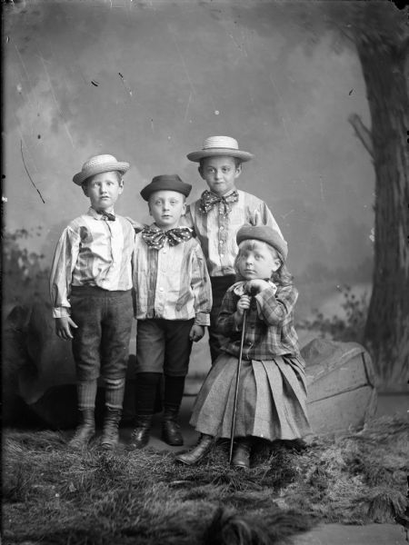 Four of the Gesell children in a studio setting in front of a painted backdrop.