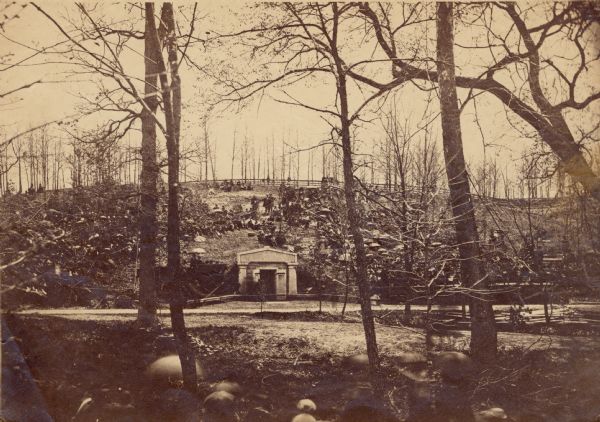 Albumen print of spectators standing and seated around the public receiving tomb in Oakridge Cemetery where Abraham Lincoln's body was placed after his funeral.