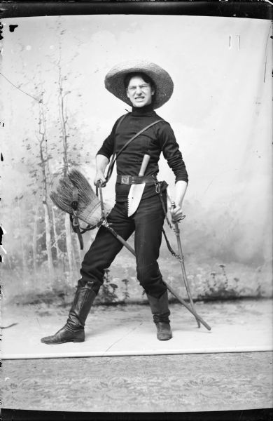 Studio portrait in front of a painted backdrop showing Arnold Gesell in a humorous pose dressed as Theodore Roosevelt in his Roughrider days.