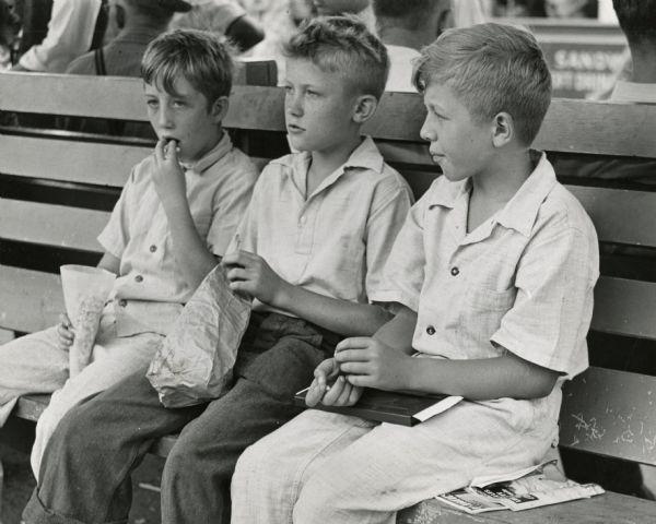 Eugene Barter, Jack Rosenthal, and Roland Small snack on popcorn on Children's Day at Wisconsin State Fair in 1941.