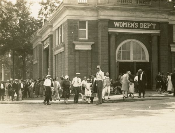 Fairgoers walk past the Women's Building at the Wisconsin State Fair. The sign on the front reads: Women's Dept."