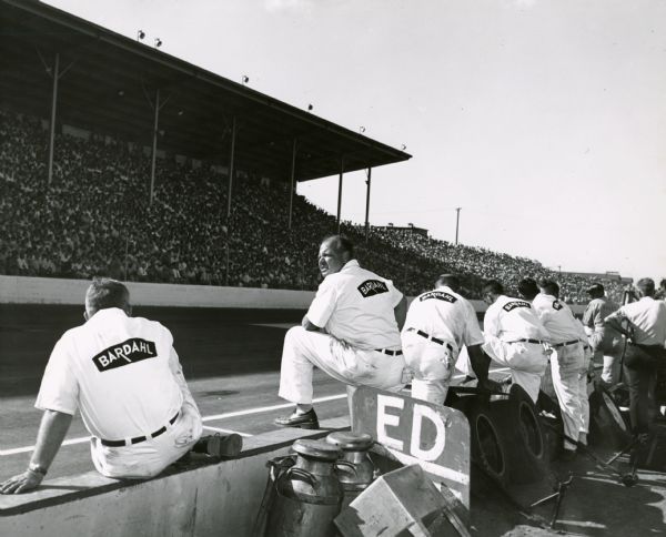 The Bardahl car's pit crew watches the action during an automobile race at the Wisconsin State Fairgrounds.