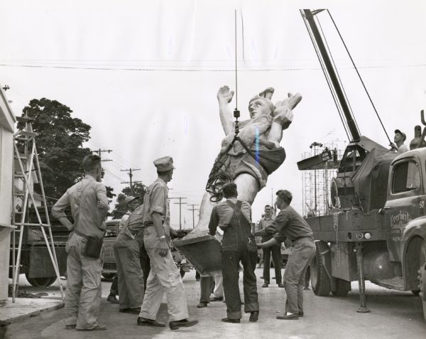 Fair employees use a crane to position a version of the Forward statue that was the symbol of the 1948 Wisconsin Centennial Exposition and State Fair.