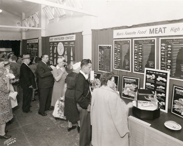 Fairgoers examine exhibits about meat, "Man's Favorite Food," sponsored by the National Livestock and Meat Board at the Wisconsin State Fair.