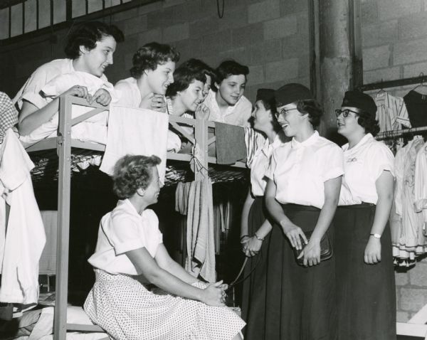 A group of girls, including several Girl Scouts in uniform, photographed in the youth residence hall at the Wisconsin State Fair.