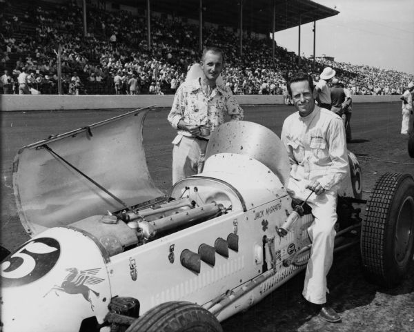 Jack McGrath, an Indianapolis 500 driver, photographed at the Milwaukee State Fair, with his cream colored Hinkle Special. McGrath died in an automobile crash in 1955.