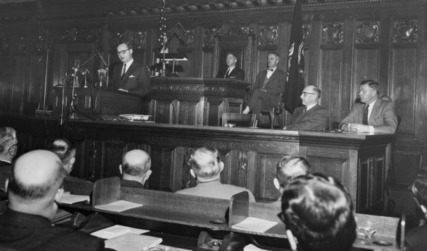 Republican Governor Walter J. Kohler, Jr., addressing the Legislature and a broadcast audience in the Assembly Chamber. Warren P. Knowles, who would later also serve as Wisconsin governor, is seated directly behind the governor.