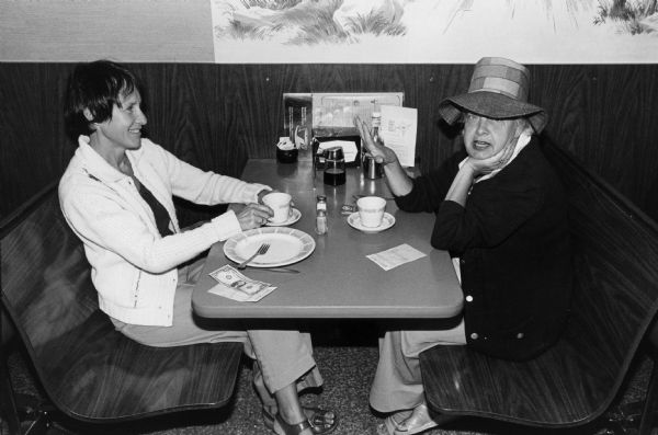 Two women enjoy a cup of coffee at a Rennebohm Drug Store restaurant.