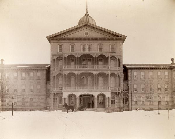 Front view of the Northern Hospital for the Insane. A horse-drawn carriage is outside the entrance.
