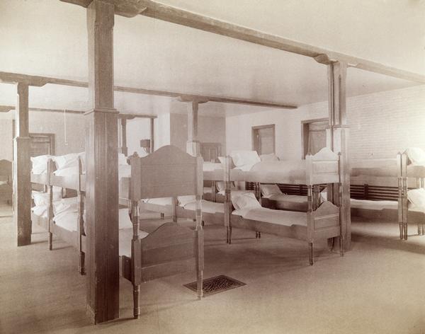 Sleeping quarters at the Wisconsin Industrial School for Boys, with several rows of bunk beds.