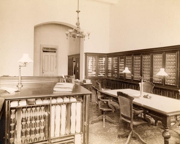 Records room at the State Public School. Volumes of "analyzed accounts" are seen in the foreground, and small drawers line the right wall.