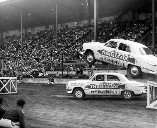 Two cars and drivers with the Swenson Thrillcade World Champion Auto Daredevils perform before an audience at the Wisconsin State Fair.