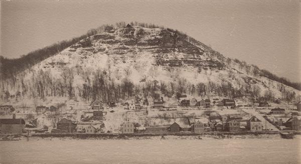 View across the Mississippi River showing a town located on a bluff, possibly Fountain City and Eagle Bluff, covered with snow.