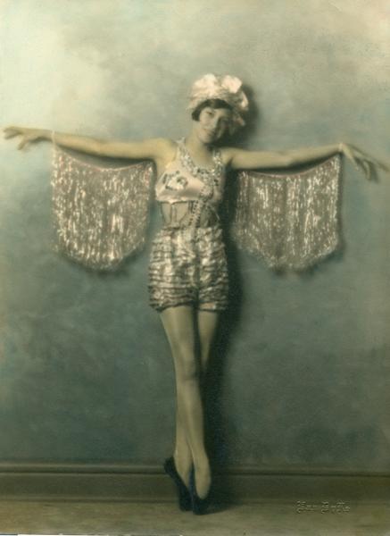An unknown dancer ("Brown") wearing a glittery pink and silver costume poses on her toes with arms outstretched at the Kehl School of Dance.
