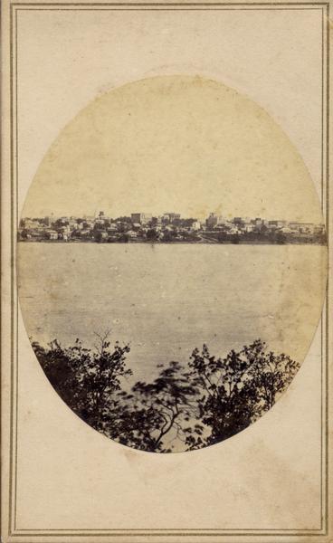 Downtown Madison viewed across Lake Monona from the resort-spa Water Cure. The skyline includes the Capitol, the dome on University Hall, several downtown buildings, and residences along the lake.