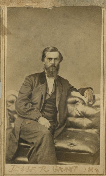 Studio portrait of a relative of Ulysses S. Grant seated on a leather sofa. Writing on the photograph indicates this is Jesse R. Grant.