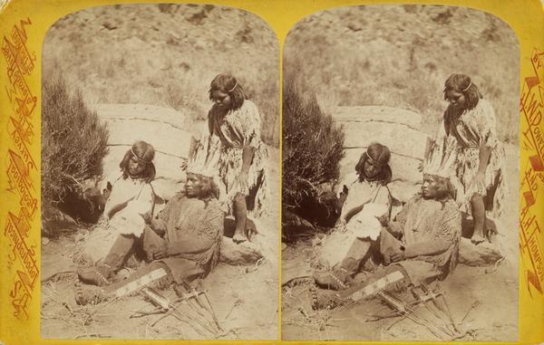 Stereograph images of a Native American man, woman, and young boy, members of the Ute Indian Tribe, looking at a rabbit skin.