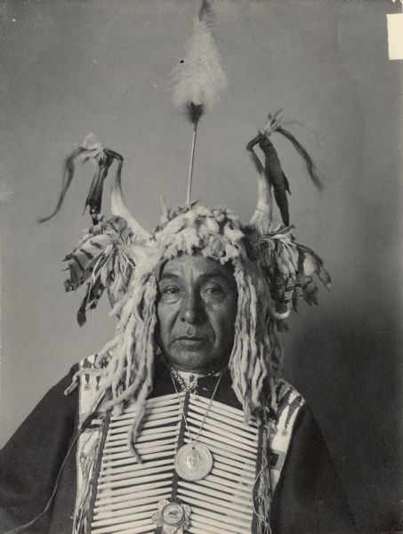 Portrait (Front) of Maka Zi (Yellow Earth), Called John Lone-Dog, in native dress with George Washington peace medal and other medal and horned headdress. Part of Siouan (Sioux) and Yankton Tribes.