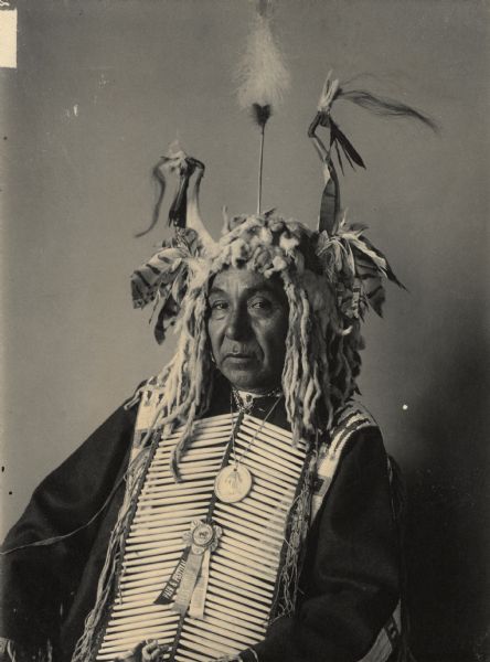 Portrait (Front) of Maka Zi (Yellow Earth), called John Lone-Dog, in native dress with George Washington peace medal and other medal and horned headdress. Part of Siouan (Sioux) and Yankton Tribes.