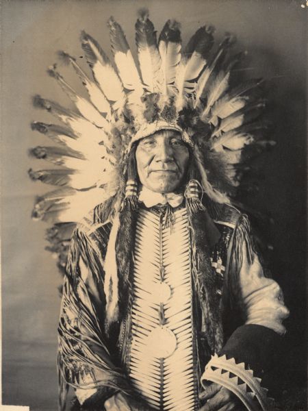 Studio portrait of Yankton Dakota man, Mato Takpeya (Charging Bear), wearing two medals. Part of Siouan (Sioux) and Yankton Tribes.
