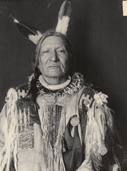 Portrait (Front) of Padani-Kokipa-Sni (Not Afraid of Pawnee) in native dress with necklace, possibly snakeskin, and medal. Part of Siouan (Sioux) and Yankton Tribes.
