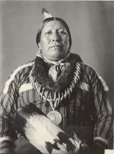 Portrait (Front) of Ray-Tah-Cotz-Tay-Sah (Roaming Chief) in partial native dress with peace medal, bear claw necklace. Part of Caddoan and Pawnee Tribes.