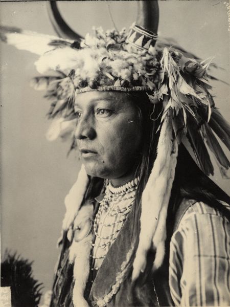 Studio portrait of Chief Paul Showeway in partial native dress with horned headdress and ornaments. Part of Waulatpuan and Cayuse Tribes.
