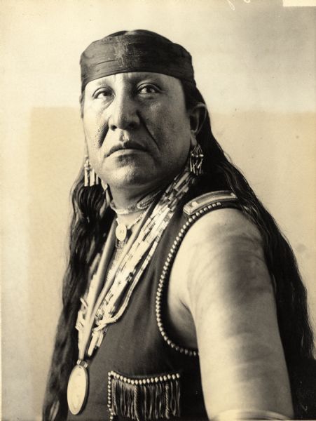 Studio portrait of Tskararalisin (Eagle Chief) in native dress with peace medal and ornaments. Part of Caddoan and Pawnee Tribes.