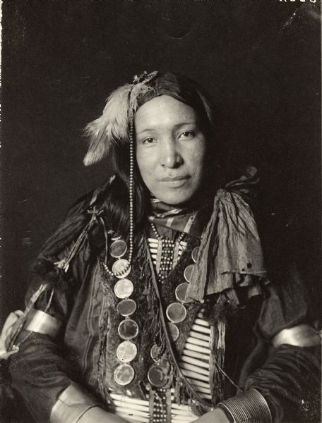 Studio portrait of Miles Turner in partial native dress with breastplate and ornaments. Part of Siouan (Sioux) and Brule Tribes.