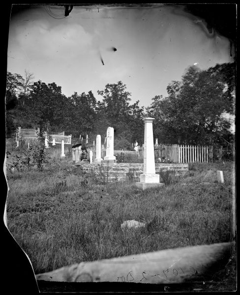 Women with parasols in Oak Hill Cemetery. Thomas and Hannah Robinson's tombstones can be seen.
