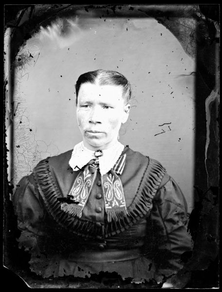 Waist-up portrait of a woman wearing a Norwegian collar. Her hair is pulled tightly back from her face.