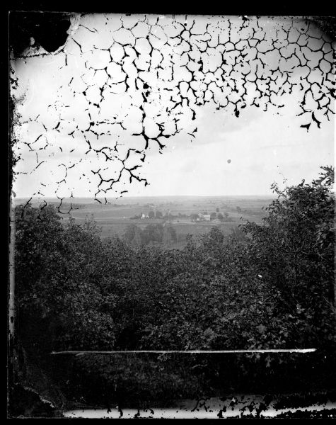 View over trees towards a farm and fields, possibly those of G. Tollefson.