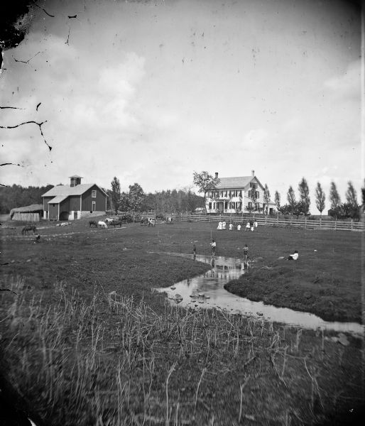 Boys fish in a stream, with cattle, horses, a farmhouse and a barn in the background.