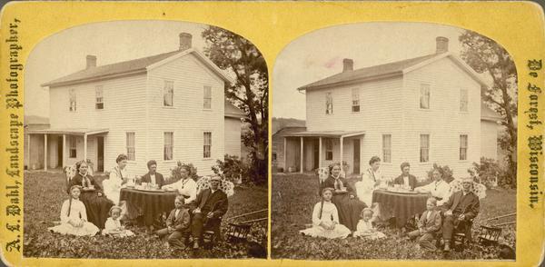 The Reverend John N. Fjeld, pastor of the Vermont Lutheran Church, enjoying coffee and a pipe with his family. His wife Gunhild on left (it could be his second wife Ingeborg wearing a necklace and sitting on Fjeld's right). A yellow mount stereograph listed as "Rev. J. Fjeld and family, Black Earth, Wis." in Dahl's 1877 "Catalogue of Stereoscopic Views."