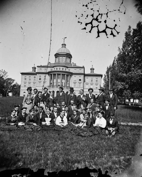 The University of Wisconsin Class of 1876 photographed on the lawn in front of Main Hall (later Bascom Hall). Prominent members of the class included Richard B. Dudgeon (back row, second from the left), who would become Madison's superintendent of schools, his sister Emma Dudgeon (back row, third from the left), who would become a teacher at Longfellow School in Madison, and Helen Remington (front row, sixth woman from the left), who would become the head of the Wisconsin Woman's Suffrage Association and wife of John Olin.