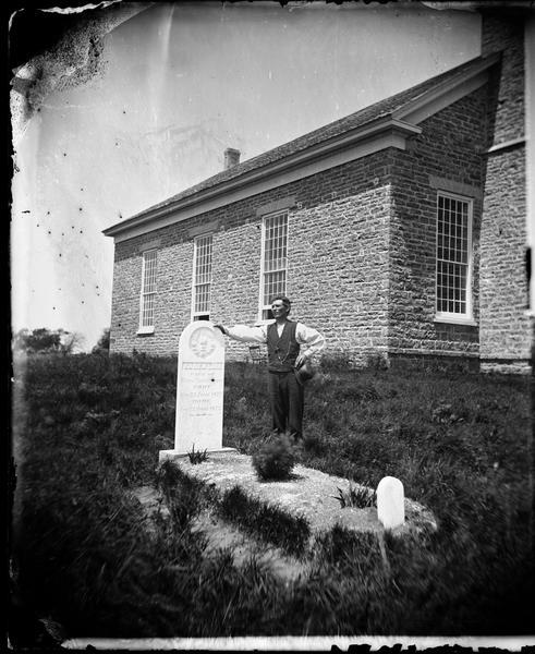 Norwegian-American farm laborer, Hans Christianson (age 44), stands next to the grave of his childless wife, Karen Luis Christianson, born 1829, who died June 13, 1873, perhaps in childbirth as suggested by the small tombstone at the foot of her grave. The grave is located adjacent to St. Paul's Liberty Lutheran Church which was erected on Liberty Prairie in 1851.  
Reproduced and described in David Mandel's Settlers of Dane County:  The Photographs of Andreas Larsen Dahl (Dane County Cultural Affairs Commission, 1985), p. 21-23.