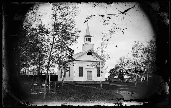 View of the front of the Union Congregational Church, a Greek Revival structure, built in 1862.  A carriage shed and cemetery are adjacent to the church.
