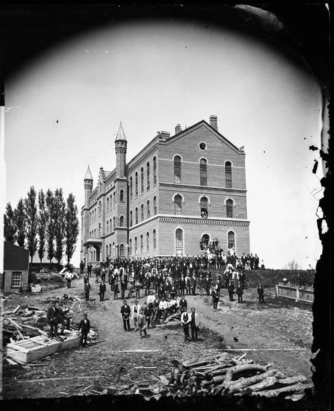 A view of the south and west sides of Luther College.  Built in 1865, the south wing was added later. The building burned May 19, 1889 and re-opened October 14, 1890. This view is cited in Dahl's 1877 "Catalogue of Stereoscopic Views."