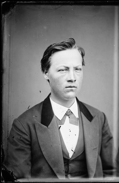Quarter-length studio portrait of a well-dressed young man.
