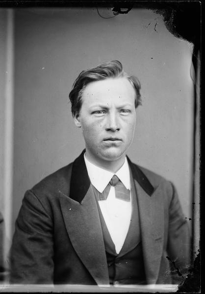 Quarter-length studio portrait of a well-dressed young man.