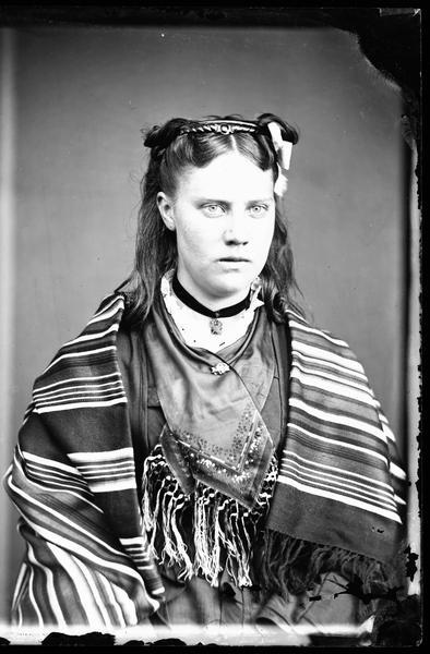 Waist-up studio portrait of a young woman in Norwegian costume.