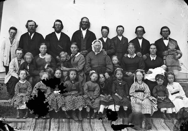 Group portrait of an extended family of nine men, five women and sixteen children.