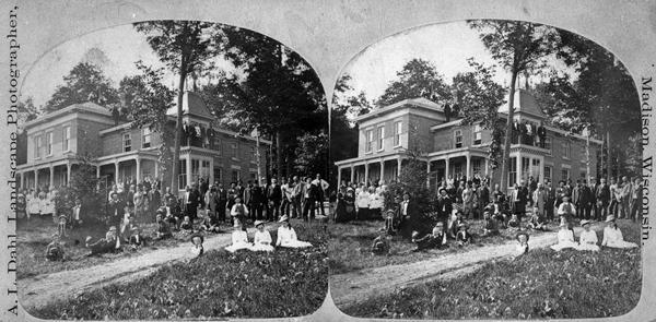 Halle Steensland, his wife Sophia, their five children and a large crowd are posed around and on the family home, later located at 733 Lakewood Boulevard, Village of Maple Bluff. (The house and farm were later owned by Robert M. La Follette, Sr.) The occasion is unknown but may be connected with the completion of major renovations and additions to the house, particularly the right wing.
