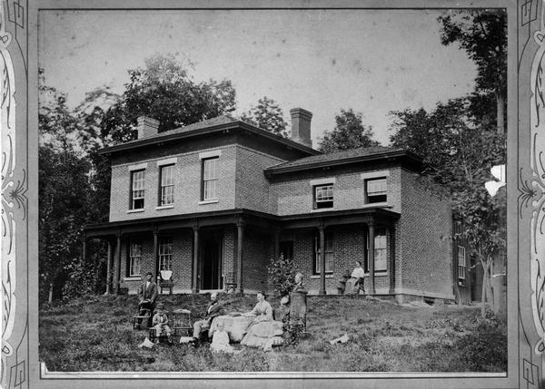 Halle Steensland and his wife Sophia pose with their five children at the family home, later located at 733 Lakewood Boulevard, Village of Maple Bluff. From left to right, the children are: Henry, Morton, Helen, Edward and Halbert. The woman on the porch is unknown.
