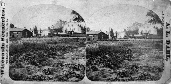 A view of the William McFarland house and the train depot published as part of the series "Wisconsin Sceneries, photographed and published by A.L. Dahl, DeForest, Wisconsin."